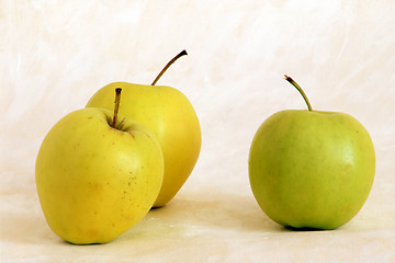 Image showing Three yellow apples on painted background