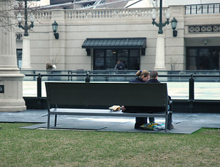 Image showing Young couple sitting on a park bench