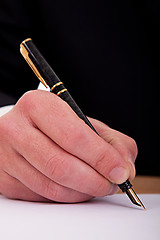 Image showing businessman signing a document  with a fountain pen 