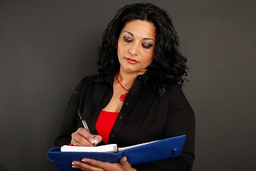 Image showing Woman writing on a binder