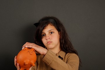 Image showing Young girl and is piggy bank