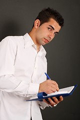 Image showing Man writing on a binder
