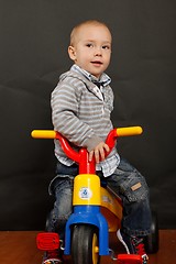 Image showing Little boy riding a tricycle