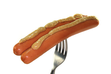 Image showing Wieners with mustard on a fork