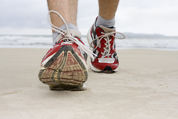 Image showing Feet of man jogging on a beach