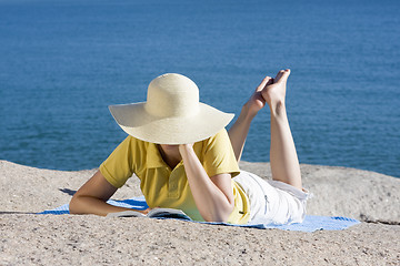 Image showing Woman reading a book at the sea
