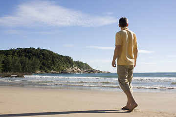 Image showing Man walking barefoot on a tropical beach