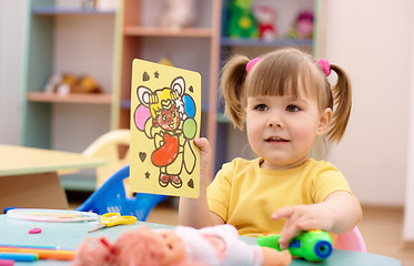 Image showing Little girl showing a picture in preschool