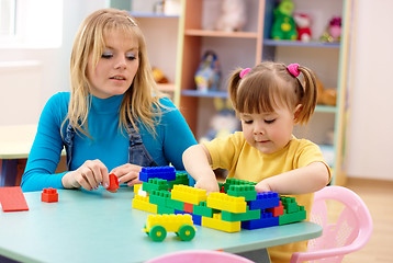 Image showing Teacher and preschooler play with building bricks