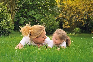 Image showing Young mother and daughter laying on the grass