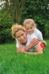 Image showing Young mother and daughter laying on the grass