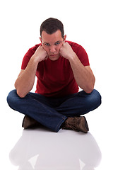 Image showing upset man sitting cross-legged on the floor