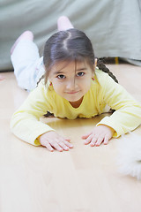 Image showing Little girl in yellow laying on floor