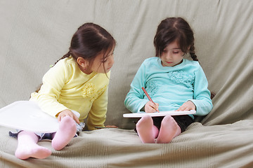 Image showing Girl looking at sister work