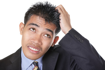 Image showing Worried businessman scratching head