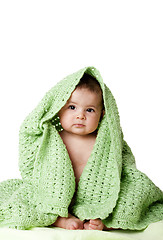 Image showing Cute baby sitting between green blanket.