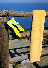 Image showing Towel and Beach Shoes on Wooden Fence