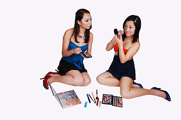 Image showing Two Chinese girls doing makeup.