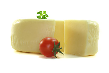 Image showing Cheese wheel with a piece of cheese