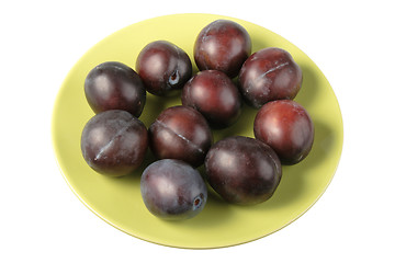 Image showing Group of dark-purple plums on plate.