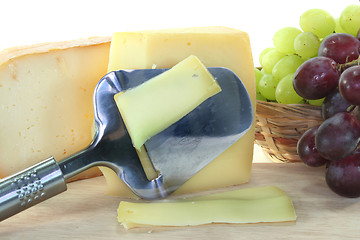 Image showing Cheese with a cheese slicer