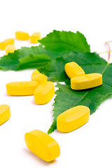 Image showing vitamin pills over green leaves