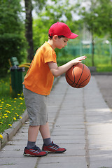 Image showing Little boy dribbling basketball sideview
