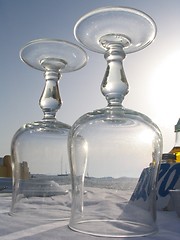 Image showing View of a sailboat on the mediterranean through wine glasses on a seaside restaurant table, Mykonos, Greece