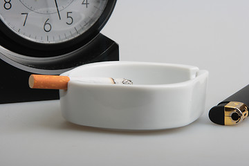 Image showing Clock and white ashtray with cigarette