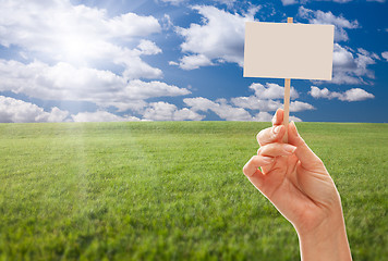 Image showing Blank Sign in Hand Over Grass Field and Sky