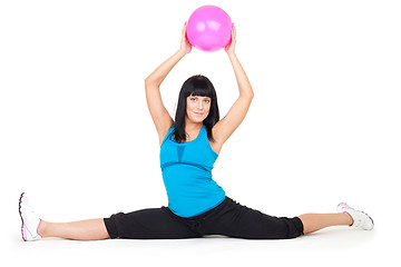 Image showing Woman do splits sitting holding ball