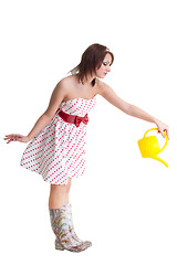 Image showing Young woman watering with water can