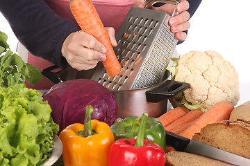 Image showing cutting carrot with stainless grater