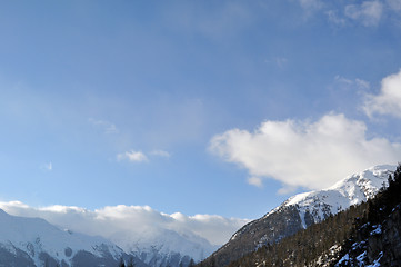 Image showing Mountain panorama with trees, snow and clouds