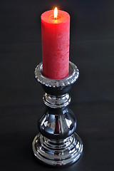 Image showing Burning red candle in silver holder