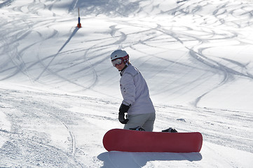 Image showing Female snowboarder kneeling in powder snow