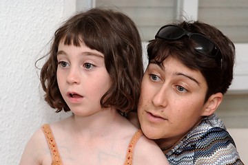 Image showing Mother and cute little daughter watch TV in great concentration