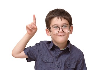 Image showing Little boy in round spectacles raising finger in funny attention gesture isolated