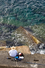 Image showing Fisherman is fishing on the sea stone, top vertical view