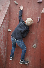 Image showing Boy climbing a wall