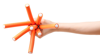 Image showing Hand with bunch of curlers