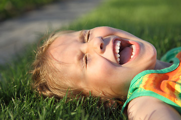 Image showing Happy girl relaxing on a grass