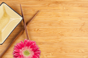 Image showing Gerber Daisy, Chopsticks and Dish on a Bamboo Background