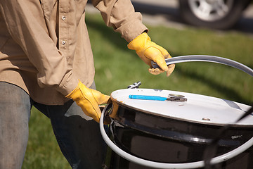 Image showing Worker Opening or Sealing Utility Drum