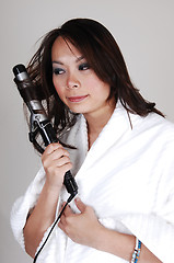 Image showing Girl curling her hair.