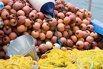 Image showing Fishing tackle: net, bucket, buoy on the boat desk 