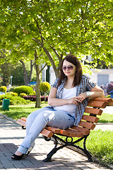 Image showing Young dark-haired girl on the bench