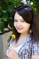 Image showing Portrait of a young dark-haired girl with a dandelion