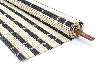 Image showing Half-rolled bamboo mat with chopsticks