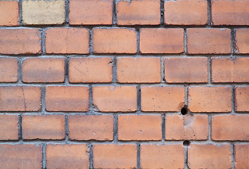Image showing Old red brick wall with two holes and one yellow brick
